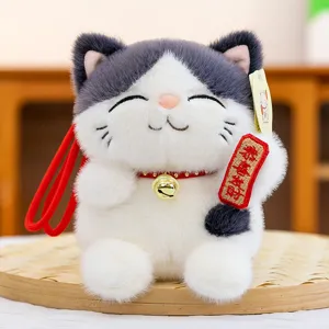 Adorable lucky cat plush toy detail, featuring soft gray and white fur with a cute red bell pendant.