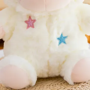 Close-up detail of cute plush sheep toy with pink and blue embroidered stars, ultra soft material.