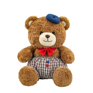 Cute plush bear toy detail with blue beret red bow tie and plaid trousers soft and adorable.