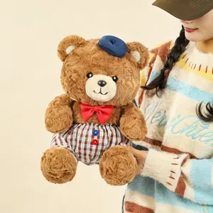 Cute brown plush teddy bear doll wearing a blue beret and red bow tie for decoration.