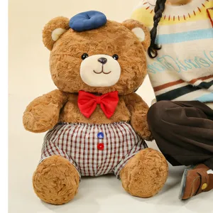 Cute brown teddy bear plush toy with blue beret and red bow tie, soft stuffed animal doll.