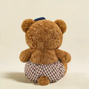 Cute brown plush bear toy featuring a blue hat and plaid shorts, soft doll pendant.