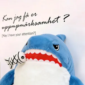 Cute blue shark plush pillow toy biting a small fish, soft and comfortable for bed sleeping.