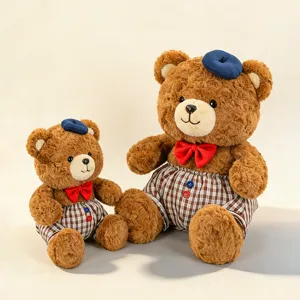 Cute plush teddy bear couple wearing blue berets and plaid trousers for decoration.