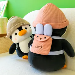 Cute penguin plush toy with backpack and beanie, soft stuffed animal doll gift for kids.