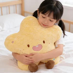Close-up detail of soft yellow star plush pillow with cute face and brown feet in child arms.