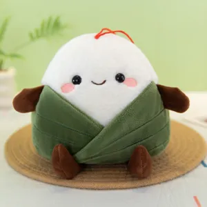 Primer plano detallado del tierno peluche de zongzi con hojas verdes y cara sonriente.