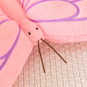 Close-up detail of a soft pink plush butterfly pillow with purple embroidery and cute antennae.