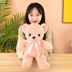 Cute pink teddy bear plush toy detailed view, soft stuffed animal holding doll for kids.