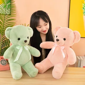 Detail view of cute plush teddy bear toys in soft pastel green and pink colors.