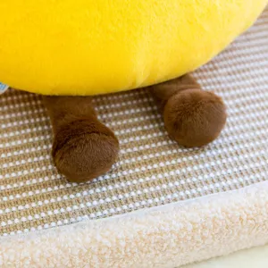 Detail de gros plan de jouet en peluche jaune avec tissu doux et adorables pieds marron.