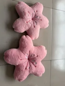 Dettaglio cuscino peluche fiore di ciliegio rosa, morbido cuscino per divano e ufficio.