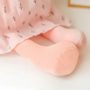 Plush rabbit toy close-up detail, soft pink dress with cute branch print, cozy pillow doll.
