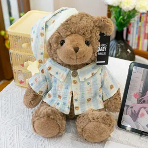 Close-up of a cute plush teddy bear wearing blue striped pajamas and a cute sleeping hat.