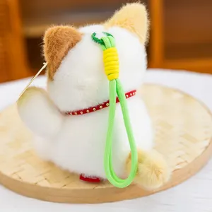 Cute lucky cat plush pendant detail view, soft plush toy featuring a vibrant green lanyard.