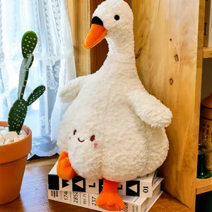 Cute white plush goose toy detail shot sitting on books with cozy home decor and soft texture.