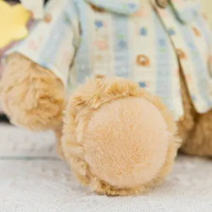 Detailed shot of a cute plush teddy bear wearing striped pajamas, soft and fluffy texture.