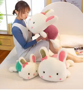 Vista dettagliata di simpatici conigli di peluche cuscino giocattoli sul letto con un modello.