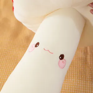 Vue détaillée d'un oreiller en peluche champignon mignon avec tissu doux et visage brodé.