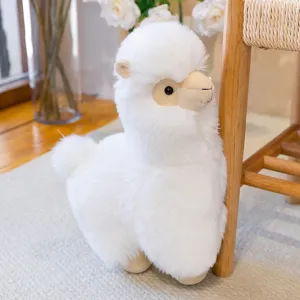 Soft white alpaca plush toy close up detail view, cozy home decor cute doll pillow.