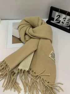 Detailed view of the winter solid color faux cashmere scarf with fringe, beige style.