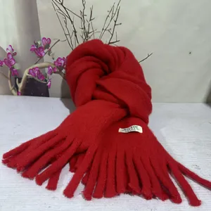 Detail shot of the soft plush red winter scarf showcasing cozy fringe and fine knit texture.
