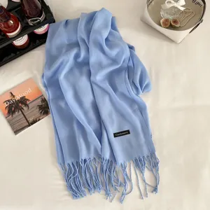 Light blue cashmere-feel fringe scarf detail shot, elegant winter accessory lifestyle display.