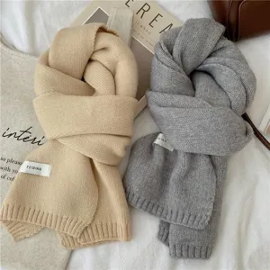 Vue détaillée d'écharpes d'hiver tricotées confortables en beige et gris avec franges.