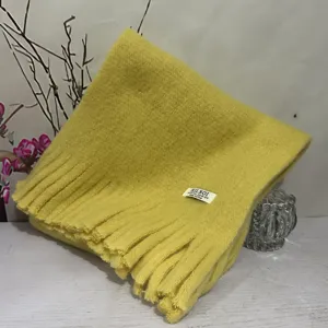 Detail shot of a soft plush solid color fringed scarf, featuring cozy and warm texture.