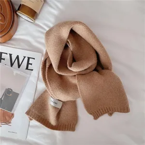 Vue rapprochée détaillée d'un écharpe d'hiver en tricot douillet couleur marron uni.