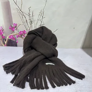 Dark brown winter plush tassel scarf detail close-up, soft warm cozy neck wrap for cold weather.