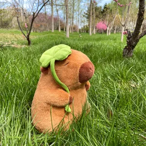 Cute capybara plush toy holding a green clover leaf, soft stuffed animal for kids and gifts.