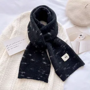 Cozy black knit winter scarf with white texture pattern and stylish label design for women.