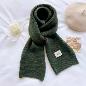 Detailed shot of the dark green knitted winter scarf with soft texture and cozy warmth.