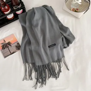 Grey cashmere-feel tassel scarf detail showcasing soft fabric texture and elegant fringed ends.