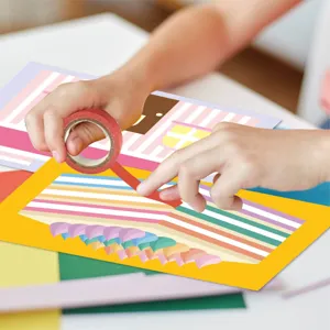 Kids DIY craft tape sticker set detailed scene showing hands creating colorful paper art.