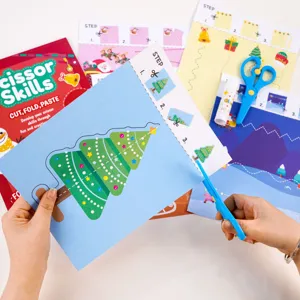 Children Christmas scissor skills activity book detail showing cut paper craft sheets and tools.