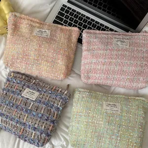 Chic tweed cosmetic bag for women, stylish plaid makeup pouch, portable travel toiletry organizer.