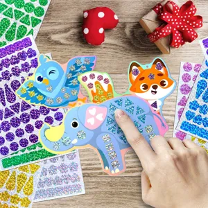 Close-up detail of kids animal mosaic sticker DIY craft set with shiny glitter pieces on desk.