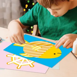 Kids DIY craft sticker set detail showing child making paper art fish design on table.