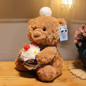 Close-up detail of cute brown teddy bear plush toy holding a mini cake, soft fluffy material.