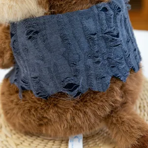 Detail view of cute marmot plush toy featuring textured distressed blue vest and soft fur.