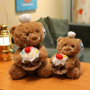 Cute plush brown teddy bear toy holding a mini cake with chef hat, soft stuffed animal gift.