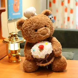 Cute brown plush teddy bear wearing chef hat and holding cake toy detail view cozy vibe