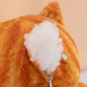 Detail shot of cute cat plush toy showing soft white cotton filling and orange fabric.