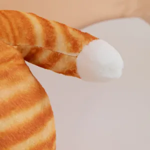 Close-up of cute striped cat plush toy with soft orange and white fabric texture details.