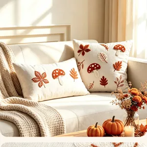 Detailaufnahme des herbstlichen Kissenbezugs mit Pilz- und Blattstickerei, Leinenoptik.