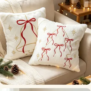 Cozy Christmas throw pillow cover featuring embroidered tree and bell with red bows. Soft plush.