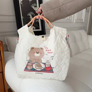 Cream quilted embroidered tote bag detail view, cute bear pattern casual crossbody shoulder bag.
