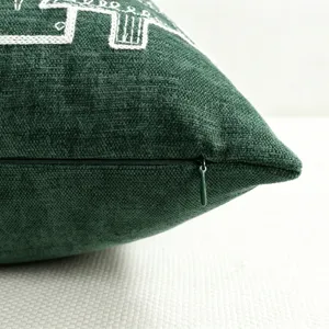 Dark green chenille Christmas throw pillow cover with elegant white embroidery and zipper.
